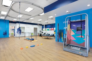 FYZICAL Clinic Interior with Balance overhead rails, harness, CDP machine, parallel bars and various physical therapy equipment