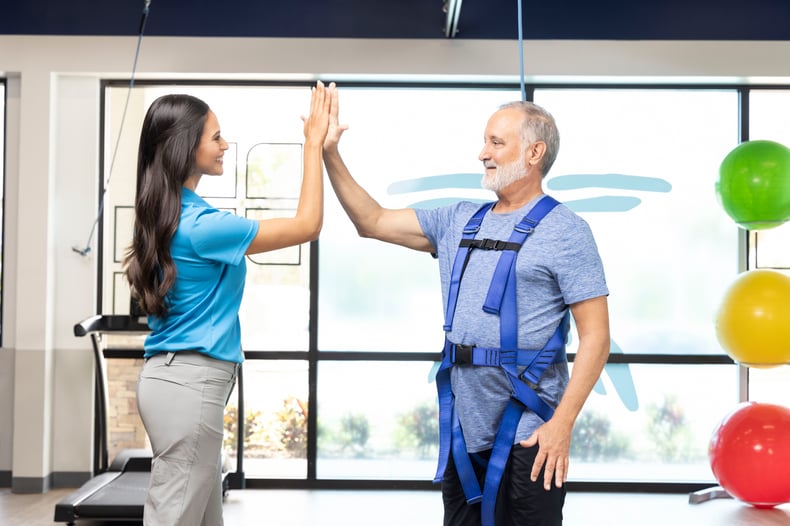 Patient and therapist high-five at FYZICAL Therapy & Balance Centers.
