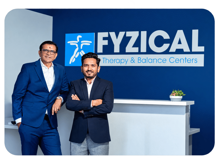 Entrepreneur Jignesh Domadia and Physical Therapist Jiten Dungarani standing in front of a FYZICAL sign.