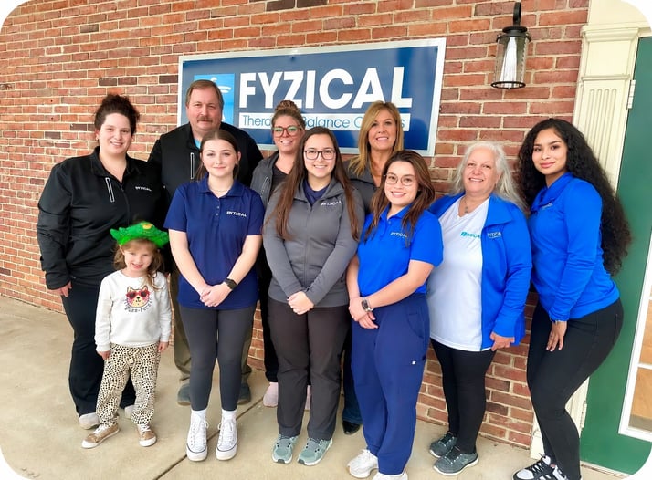  Barry Brown, PT, and FYZICAL clinic owner, with his staff in front of the FYZICAL building
