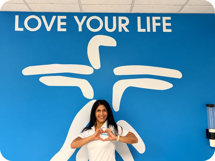 FYZICAL's Physical therapist posing in front of a sign. 