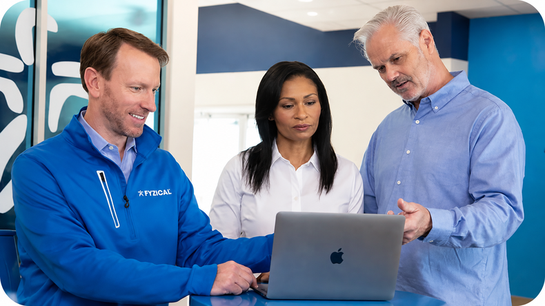 3 people collaborating while looking at a laptop screen as they prepare to sell their physical therapy practice