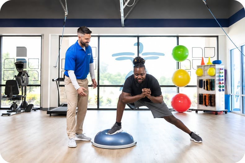 Physical Therapist and man stretching in the FYZICAL facility. 