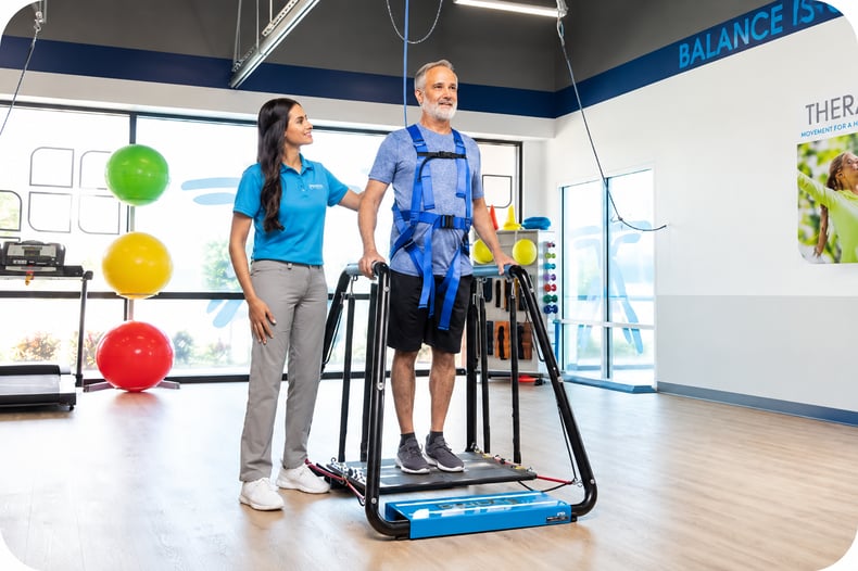 A physical therapist helping a patient do a balance exercise, under the SAFE Act.