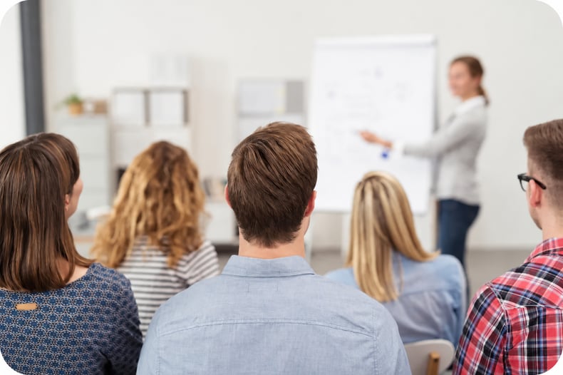 The backs of physical therapy managers heads in a classroom, learning how to be a better manager in their PT practice.