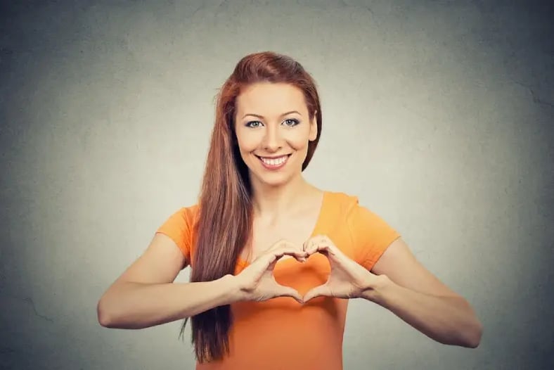 woman making heart symbol over her chest