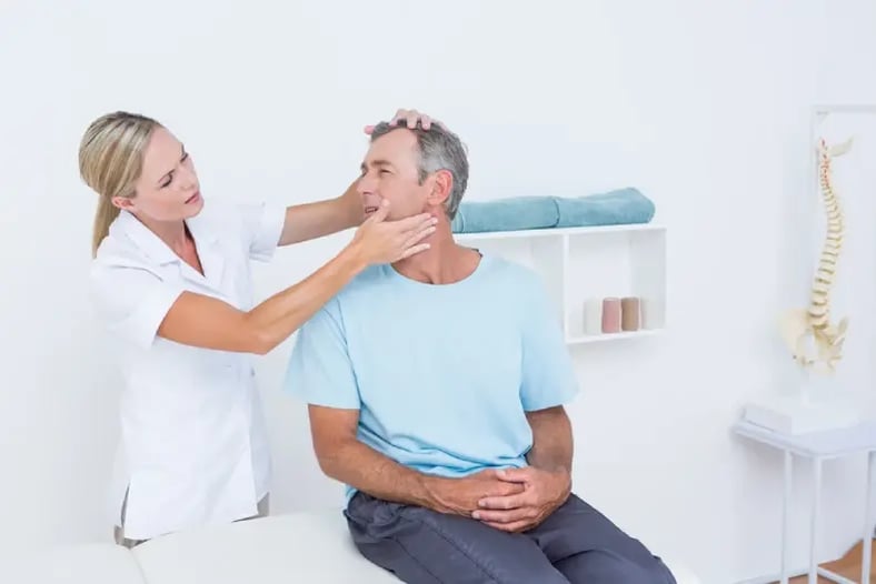 physical therapist stretching patient's neck