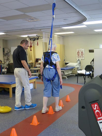 elderly woman doing suspended walking with physical therapist