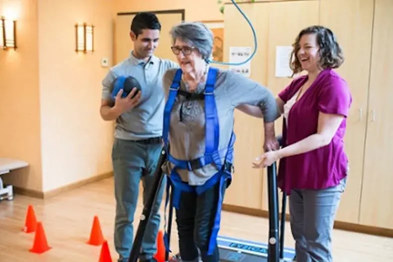 patient getting help walking from physical therapists