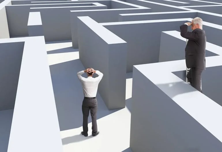 Two businessmen standing in maze being captured