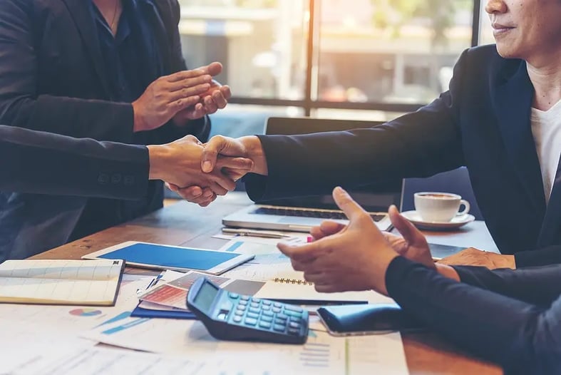 business people shaking hands at table