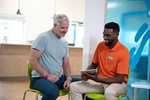 elderly patient being shown a tablet by therapist