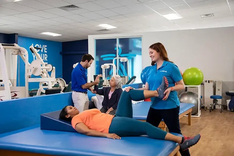 Therapist stretching patient's leg